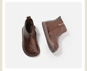 Botines de cuero marrón para niños pequeños con forro polar y cierre de cremallera lateral.