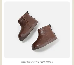 Vista detallada de botines de cuero marrón para niños pequeños con cremallera lateral útil