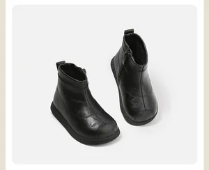 Vista detallada de botines de cuero negro para niños con cremallera lateral y punta redonda.