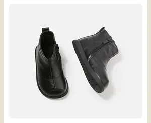 Detalle de botines de cuero negro para niños pequeños con cremallera lateral funcional