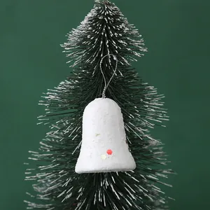 Detailed view of white foam bell Christmas ornament with sequins on green tree