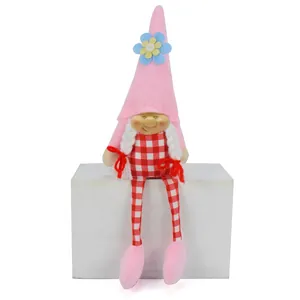 Detailed view of a cute pink plush gnome with a resin face and red checkered overalls