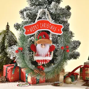 Festive Christmas pine needle wreath ornament featuring a plush Santa Claus and red banner