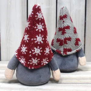 Close-up detail of knitted snow pattern hats on plush Scandinavian Christmas gnomes