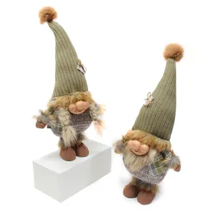 Detail view of two Nordic forest gnome dolls with resin faces and knit hats on white background.