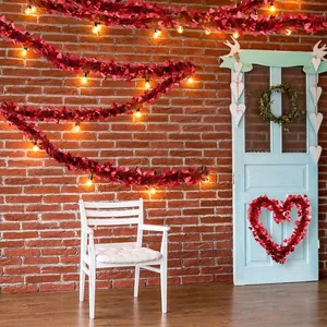 Décoration de Saint-Valentin avec guirlandes et couronne de cœurs rouges sur un mur en briques