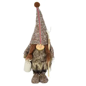 Dettaglio di una bambola gnomo primitiva in peluche con viso in resina e pelliccia.