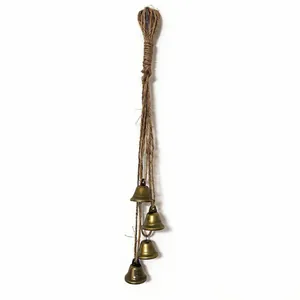 Vintage brass bells hanging on a natural hemp rope for rustic home and garden decoration