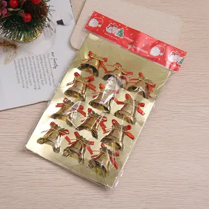 Detalle de 12 cascabeles dorados de Navidad con lazos rojos en su embalaje