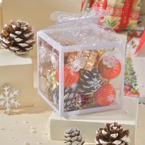 Detailansicht einer PVC-Weihnachtsbox, gefüllt mit roten Kugeln und Tannenzapfen