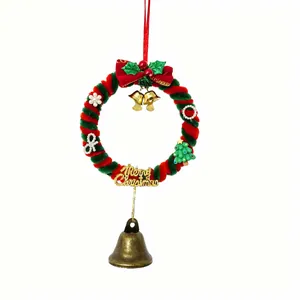 Dettaglio di una ghirlanda natalizia rossa e verde con campanelle e ciondoli decorativi.