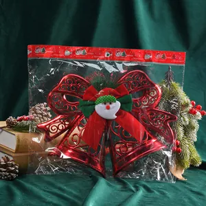 Red Christmas Santa Claus bow bell ornament decoration in clear packaging on green velvet