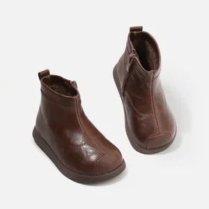Botines clásicos de piel marrón para niños con forro polar cálido y cremallera lateral.
