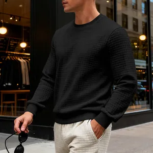 Detailed view of men's black crewneck sweatshirt with small square quilted texture.