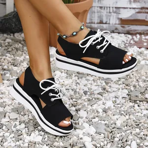 Close-up detail of black platform lace-up sandals with white thick soles