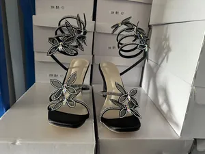 Detailansicht der schwarzen Stiletto-Sandalen mit Strassschleifen und Wickelriemen
