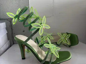 Detailansicht von grünen Satin-Sandalen mit Strass-Schmetterling-Wickelriemen