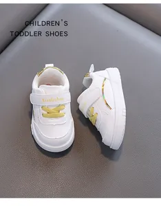 Dettaglio di scarpe primi passi in pelle bianca con lacci gialli e velcro