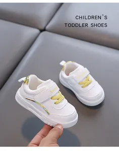 Dettaglio delle scarpe da passeggio per bambini bianche con suole morbide antiscivolo.