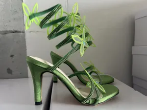 Detailansicht grüner Satin-High-Heels mit Strass-Schmetterlings-Spiralriemen-Design.