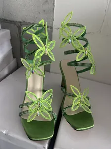 Detailansicht lindgrüner Sandalen mit Strass-Schmetterlingen und Spiralriemen