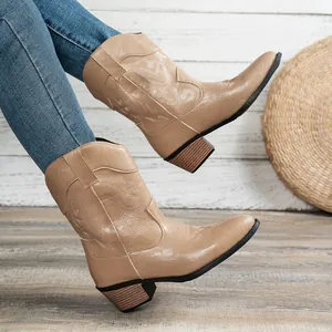 Close-up of khaki Western cowboy boots featuring delicate embroidery and chunky heels