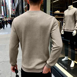 Close-up detail view of men's beige crew neck sweatshirt with unique square grid texture.