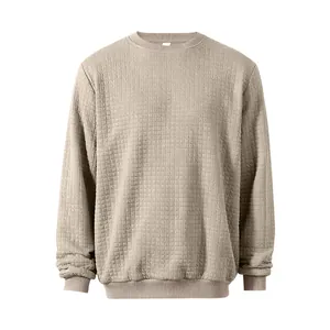 Close-up of men's khaki sweatshirt featuring textured square grid and ribbed cuffs