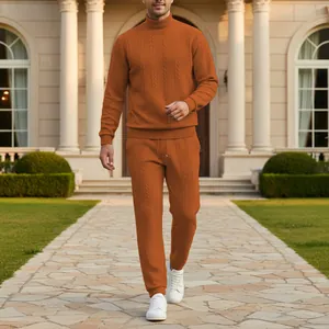 Vista dettagliata del set maglione dolcevita e pantaloni in maglia a trecce arancio bruciato.
