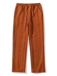 Detailed macro view of orange men's cable knit trousers featuring drawstring elastic waist