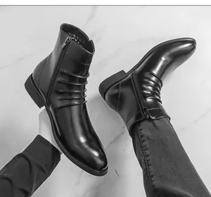 Détail de bottines Chelsea en cuir noir avec bout pointu et fermeture éclair latérale.