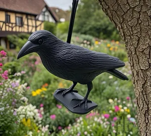 Close-up of realistic black crow decoy showing detailed feather texture in garden