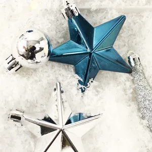 Weihnachtssterne und Kugeln in Blau und Silber auf weichem weißem Kunstschnee