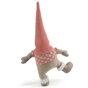 Close-up of a Christmas gnome ornament with a tall pink hat in a playful kicking pose