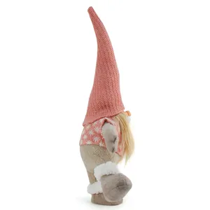 Detailed side view of a pink knitted Christmas gnome ornament standing on one leg