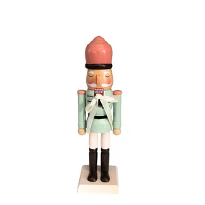 Close-up of a 25cm pastel wooden nutcracker soldier ornament with a cream ribbon bow