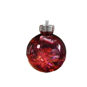 Red translucent Christmas ball ornament filled with shiny tinsel and silver cap