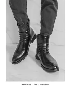 Détail de bottines Chelsea en cuir noir avec tige plissée et bout pointu élégant