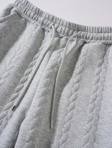 Close-up of grey textured knit joggers waistband with elastic and drawstring
