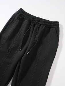 Close-up of black cable knit textured trousers with adjustable drawstring waistband