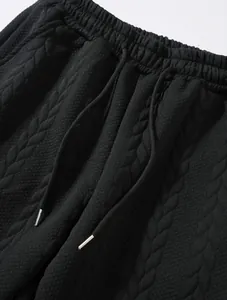 Primo piano della fascia in maglia jacquard nera con cordini regolabili