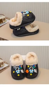 Detailansicht der Astronauten-Anhänger und des warmen Kunstfellfutters an schwarzen Clogs.