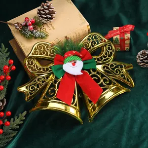 Detailed view of a gold Christmas bell ornament with plush Santa Claus and ribbons