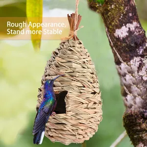 Outdoor hand-woven grass bird nest hanging from a tree branch in a natural garden environment
