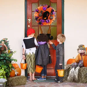 Couronne d'Halloween pour porte avec longues jambes de sorcière et tulle orange