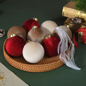 Detailed view of red, cream and gold velvet Christmas balls on a woven tray