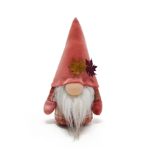 Detailed view of a fall harvest gnome with maple leaf accents and velvet hat.