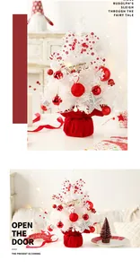White tabletop mini Christmas tree with red ornaments and a rotating music box mechanism
