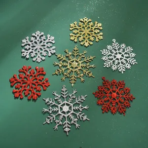 Detail von glitzernden Kunststoff-Schneeflocken als Weihnachtsbaumschmuck in verschiedenen Farben