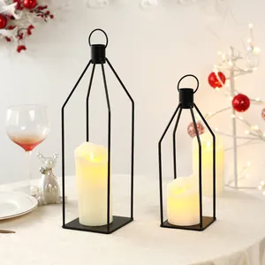 Dettaglio di lanterne minimaliste in ferro nero con candele LED su una tavola festiva
